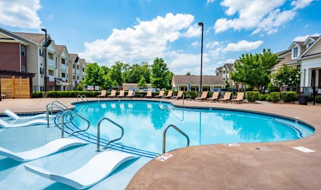 Relax and unwind poolside a swimming pool in a neighborhood